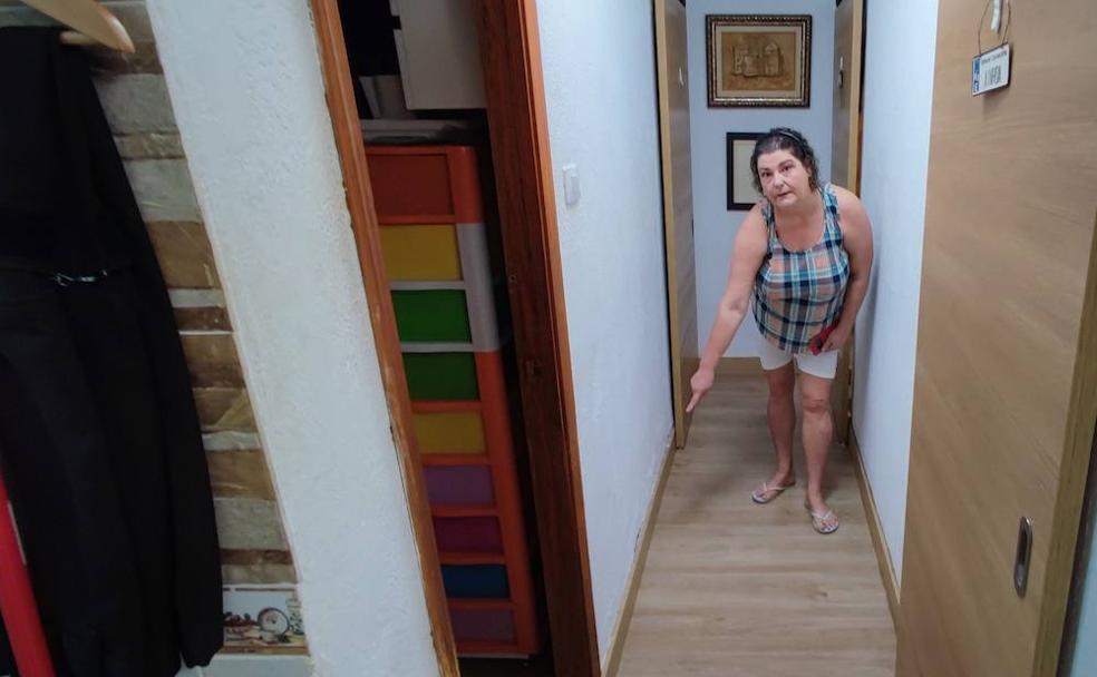 Sandra García muestra los efectos de las filtraciones de aguas negras en la pared. 