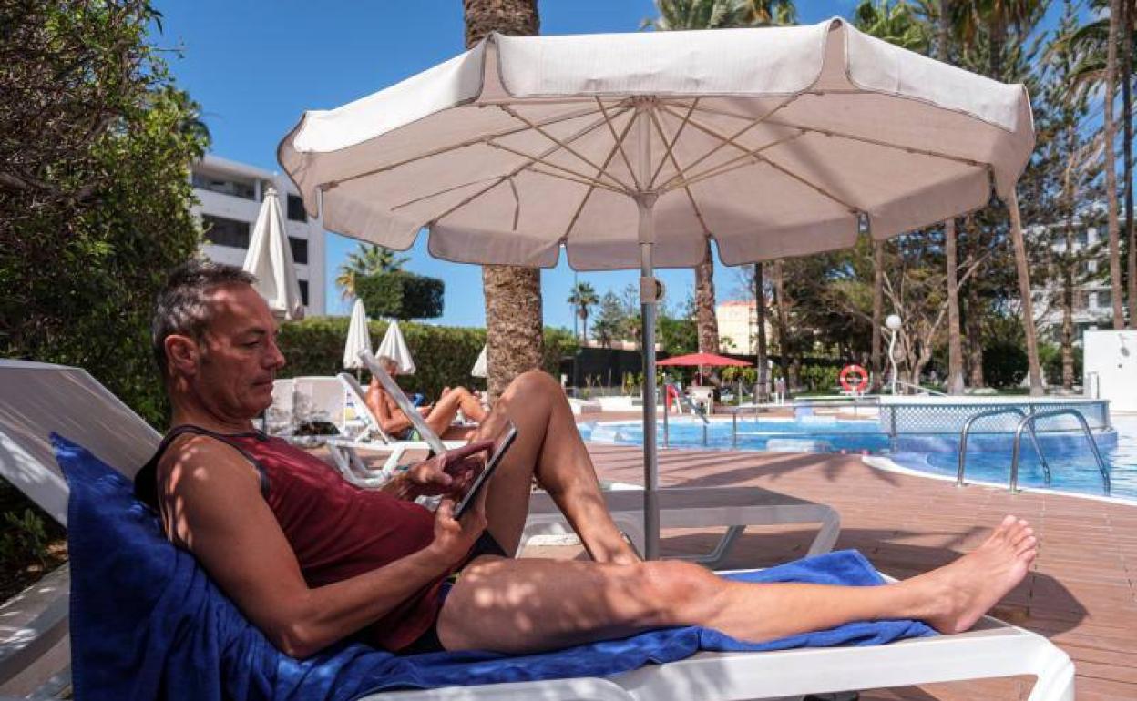 Un especialista en tecnologías de la información trabaja con su tablet desde la hamaca de un hotel del Sur. 