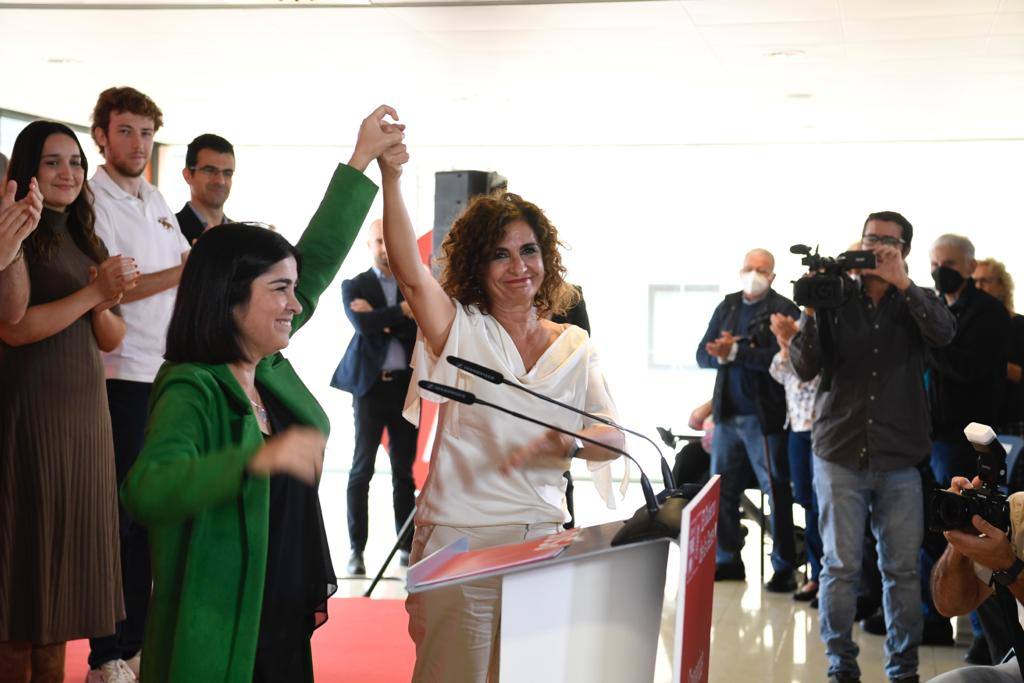 Carolina Darias y María Jesús Montero levantan juntas sus manos. 