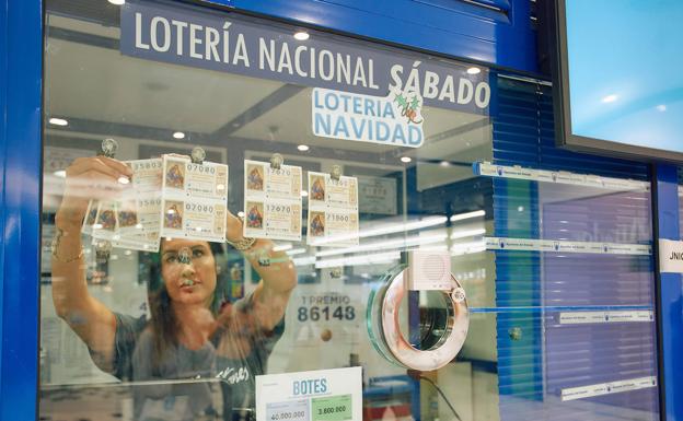 Claudia Reyes coloca los números de lotería de este año en su despacho en El Mirador.