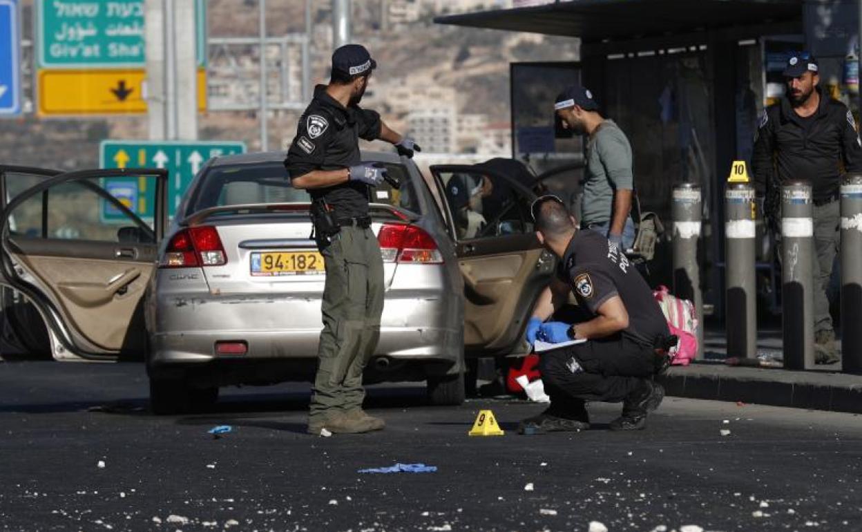 Las Fuerzas de Seguridad de Israel inspeccionan el escenario de una explosión registrada en una parada de autobús en una de las entradas de Jerusalén. 