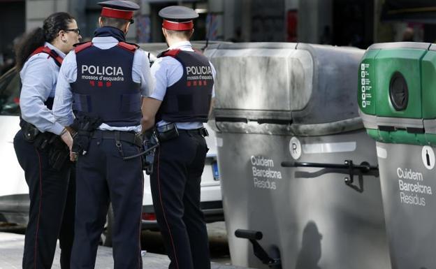 Agentes de los Mossos d'Esquadra este martes donde se ha hallado el cadáver mutilado de una persona dentro de una maleta en un contenedor.