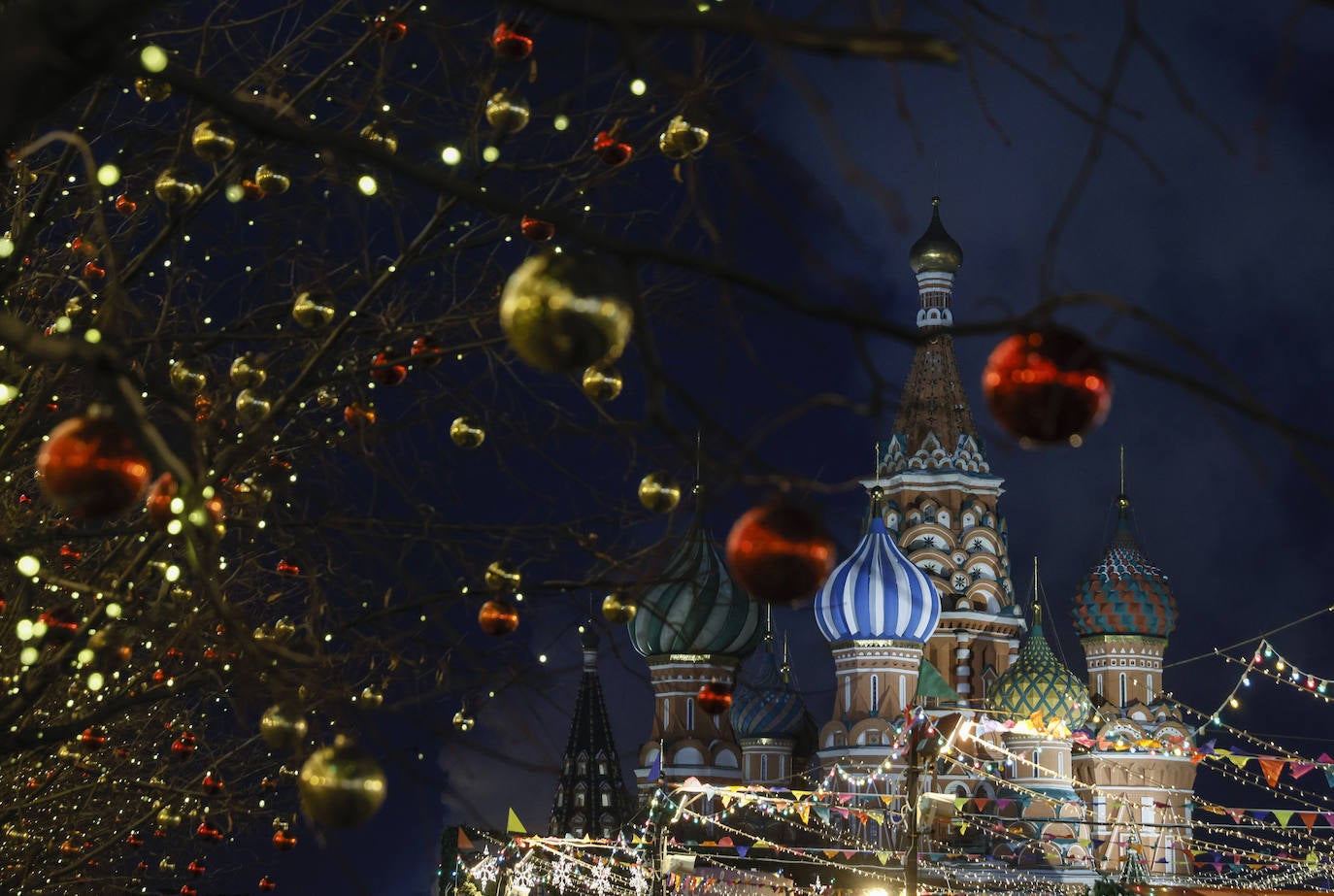 Las luces y bolas navideñas que engalanan las inmediaciones de la Catedral de San Basilio, en la plaza Roja de Moscú, Rusia.