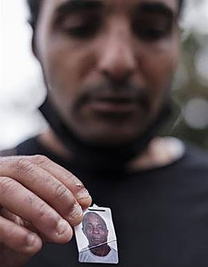 El hijo mayor del ciudadano de Sierra Leona Héctor Abioseh Ibowu sostiene una foto de su padre. 