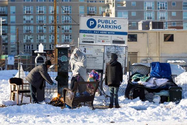 Un grupo de personas sin hogar se calienta con una hoguera en el centro de Denver, Colorado, el 22 de diciembre de 2022.