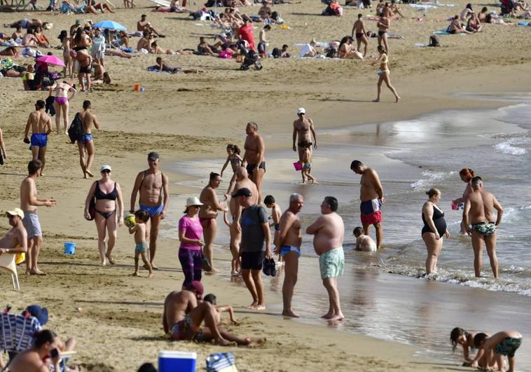La playa de Las Canteras se llena de gente que aprovecha el calor para pasar el día en ella.