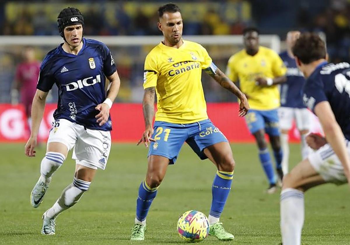 Jonathan Viera controla el balón ante la presión de los jugadores del Real Oviedo.