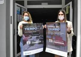 Dos trabajadoras de la Asociación Párkinson de Gran Canaria posan con carteles de la campaña de este año.