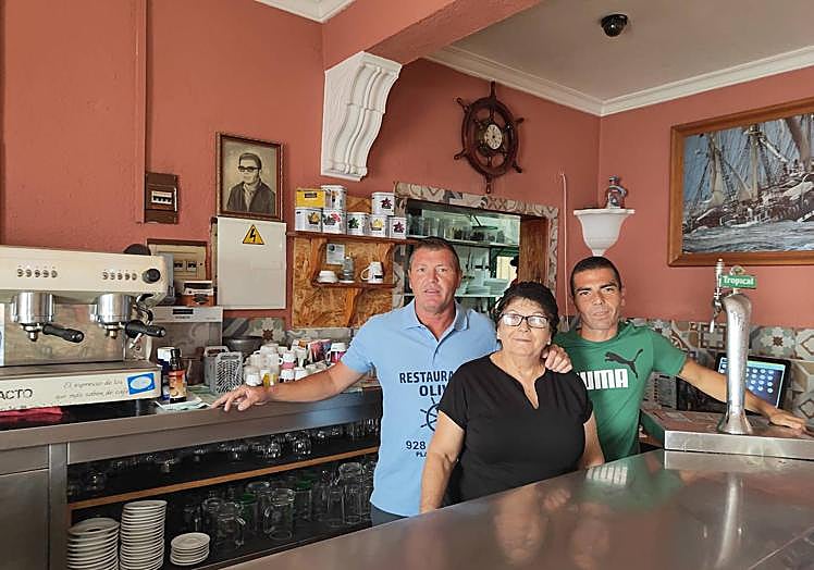 Paca Rosa junto a sus dos hijos, Gomauro y Yonay, detrás de la barra del bar Oliva.