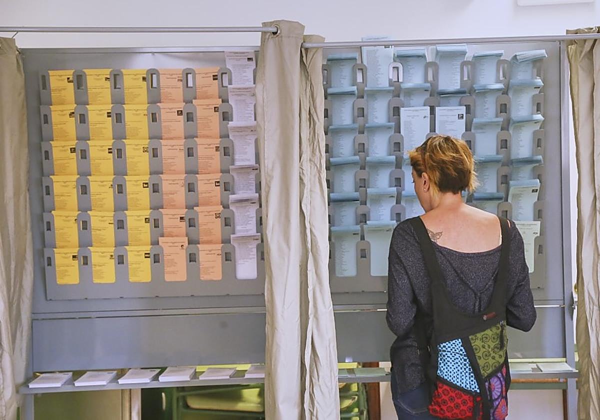 Una ciudadana elige entre las papeletas de los partidos en las elecciones pasadas.