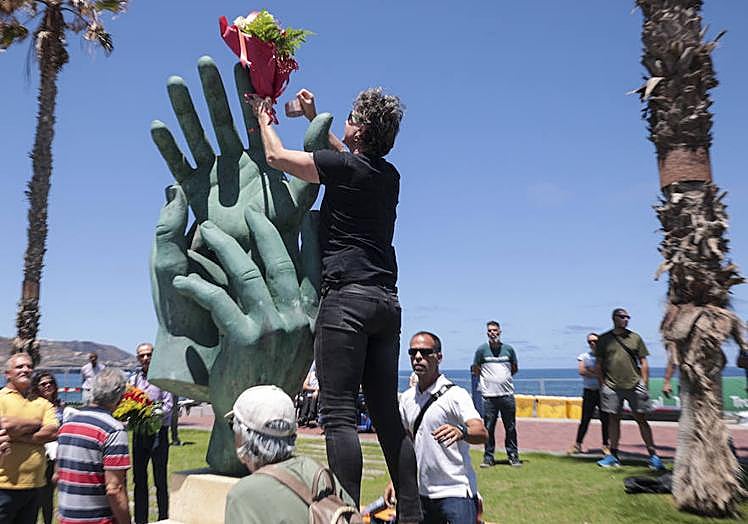 Francisco Viera coloca unas flores en la escultura.
