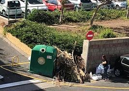 Una vecina deposita las bolsas de basura en el lugar en el que antes estaban los contenedores.