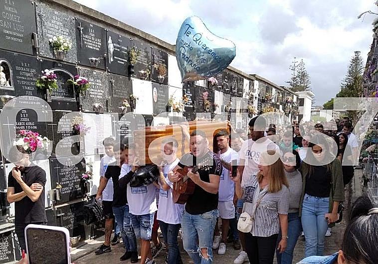 Varios seres queridos portan, emocionados, el férretro del joven fallecido.