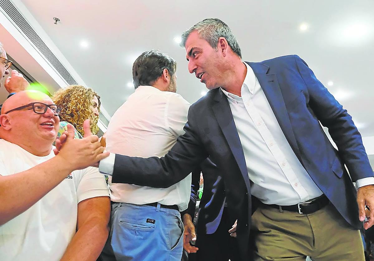 Manuel Domínguez (d), recibe la felicitación de sus compañeros de partido durante el seguimiento de la jornada electoral.