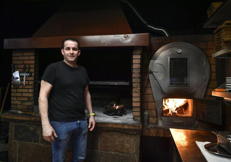 Carmelo González, junto al horno donde asa la mayor parte de sus platos.