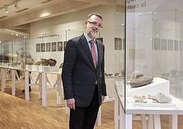 Héctor Roldán Delgado, ante la vitrina donde luce parte de los materiales de su padre donados al Museo Arqueológico de Fuerteventura, entre ellos un molino de mano en basalto.