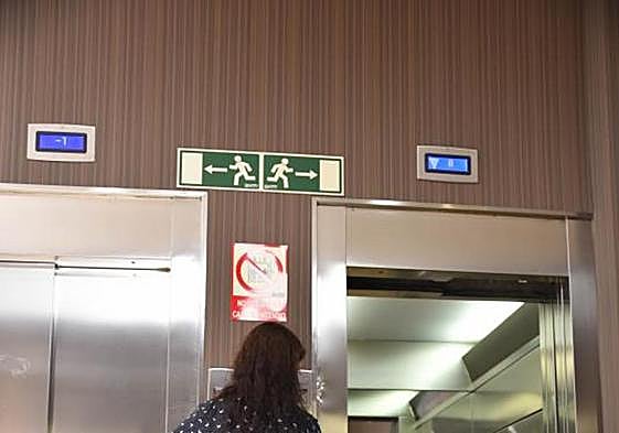 Una mujer espera por el ascensor en su vivienda.