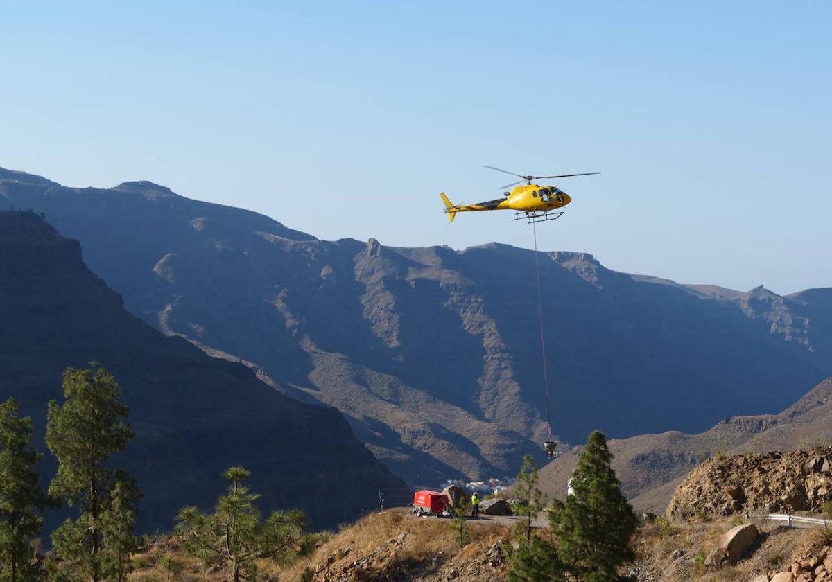 Un helicóptero descarga material de obra para las bases de las torretas de la línea de alta tensión.