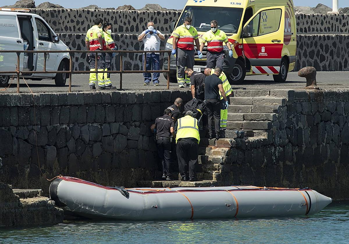 Momento en que sacan el cadáver de una migrante fallecida en una lancha.