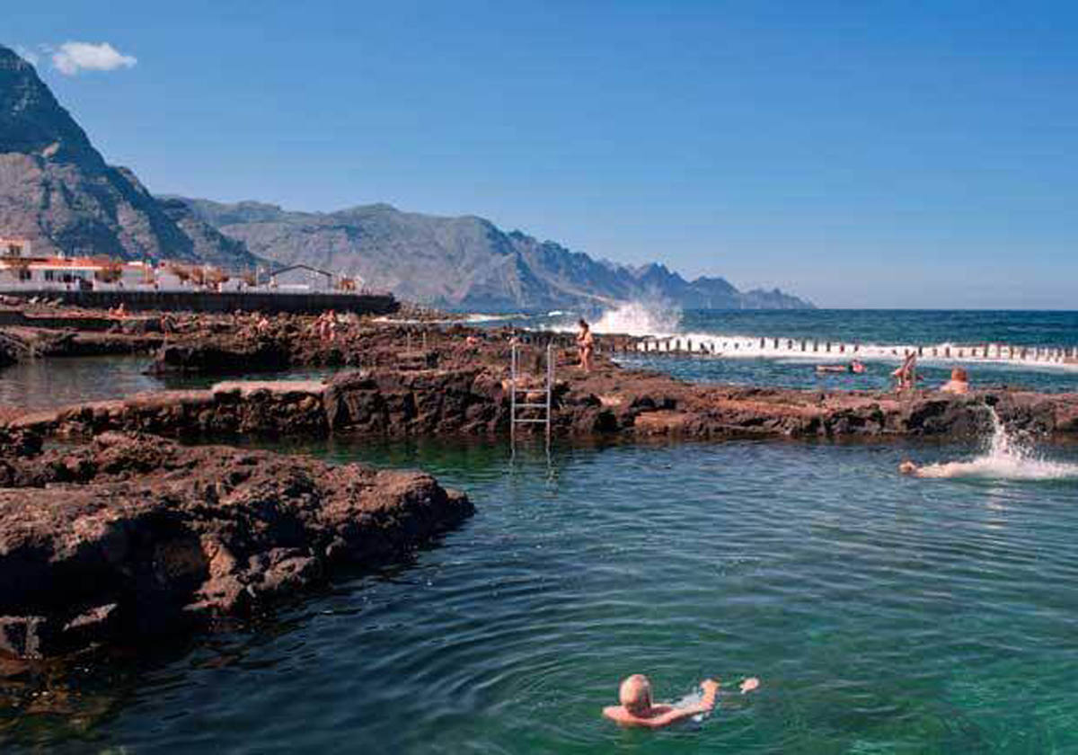 Una piscina natural con tubos volcánicos para toda la familia: Lo más parecido a una fortaleza medieval, aunque rellena de placentera agua oceánica, se encuentra en las Islas Canarias en Las Salinas de Agaete, en Gran Canaria. Tres excelentes piscinas naturales protegidas del mar abierto simulan un castillo por sus singulares pilones de hormigón a modo de almenas, que aminoran aún más las acometidas del oleaje. Estos charcos, conectados por tubos volcánicos, lo tienen todo para disfrutar de baños familiares relajantes y con grandes vistas de la acantilada costa del noroeste.