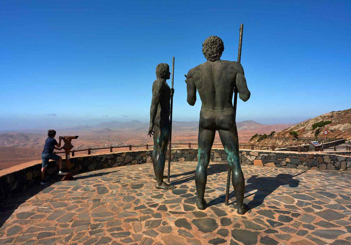 Paisajes aéreos a través de la historia.- En lo alto de la degollada que da acceso a la villa histórica de Betancuria a través de la carretera FV-30, se encuentra el Mirador de Guise y Ayoze, los dos reyes aborígenes durante la conquista de la isla en el siglo XV, representados en sendas esculturas de bronce de 4 metros de altura. Una parada en este mirador es de valorar para apreciar desde la altura los paisajes suaves y redondeados de la zona más antigua y erosionada de Fuerteventura, al norte, y al sur, el barranco que desciende hacia Betancuria. Esta zona cuenta con una importante protección bajo la declaración del Parque Rural de Betancuria, e incluso llegó a ser una de las propuestas para la declaración del primer Parque Nacional de Zonas Áridas en todo el territorio nacional.