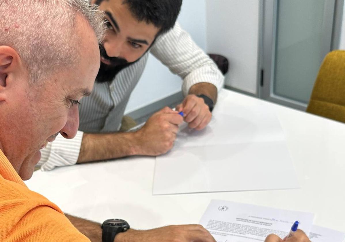 Santiago Alejandro firmando los últimos papeles de la cancelación de sus deudas.
