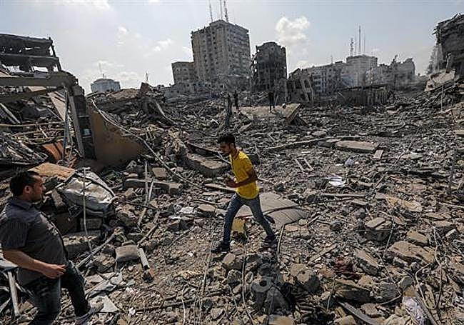 Palestinos caminan entre los escombros tras un ataque a la zona de Al-Ramal, tras un ataque israelí, este martes en la Ciudad de Gaza.