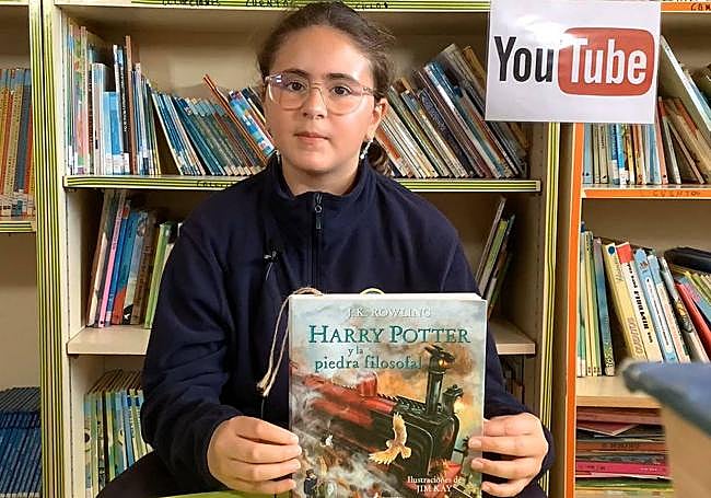 Una estudiante presentando el libro que se leyó en uno de los vídeos que hacen.