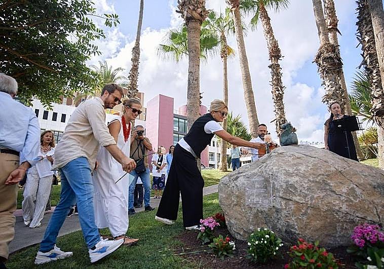 Arancha (de blanco) y su marido, depositando una flor por Clara.