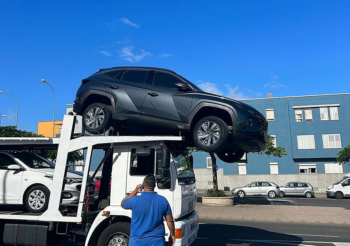 Imagen del vehículo a punto de caer de la grúa.