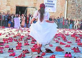 Las pisadas de la ausentes, en forma de zapatos rojos, alientan la lucha contra la violencia machista en una performance organizada en Cáceres.
