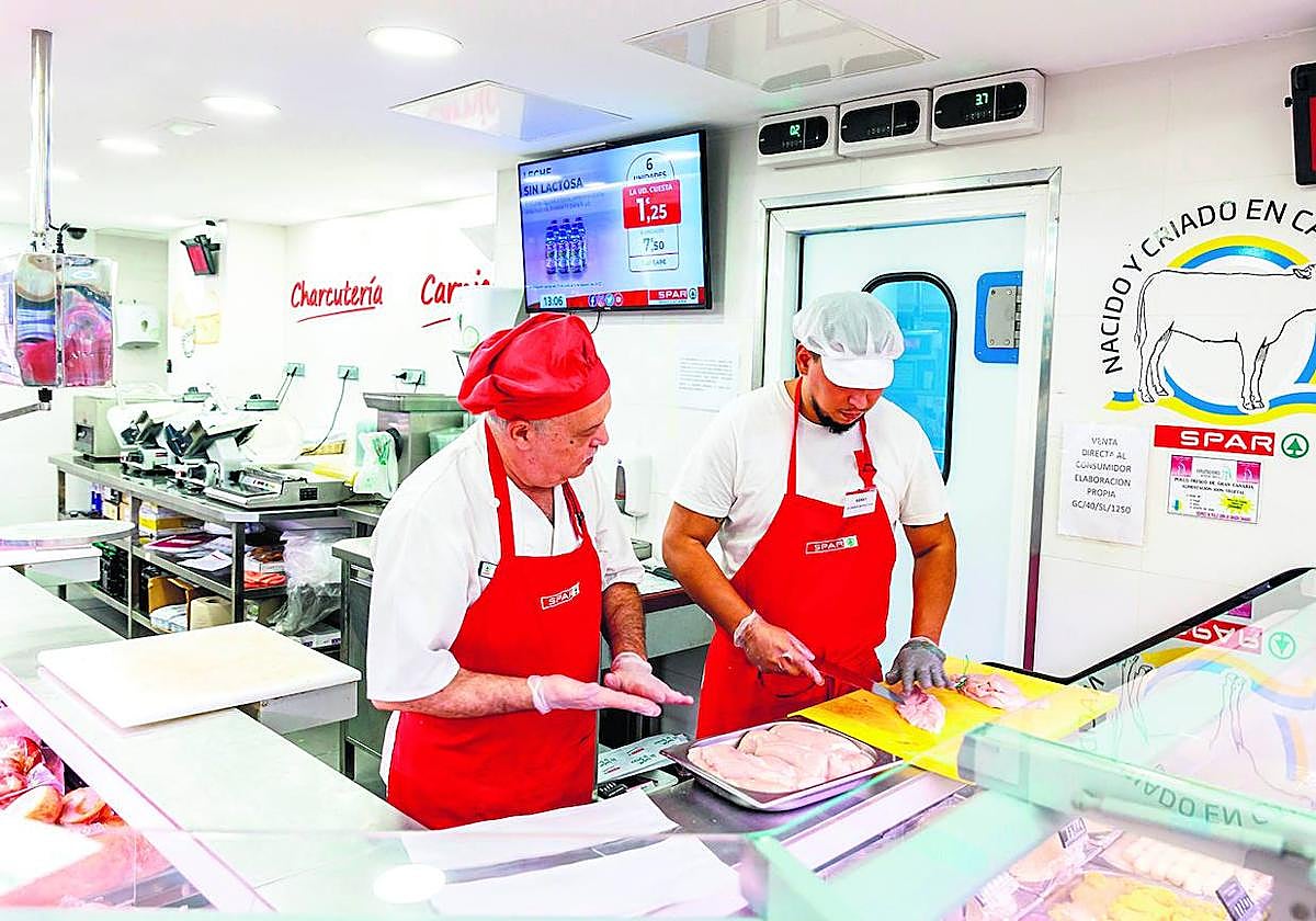 Uno de los participantes de la Escuela de Carnicería aprende de uno de los expertos carniceros de SPAR Gran Canaria.