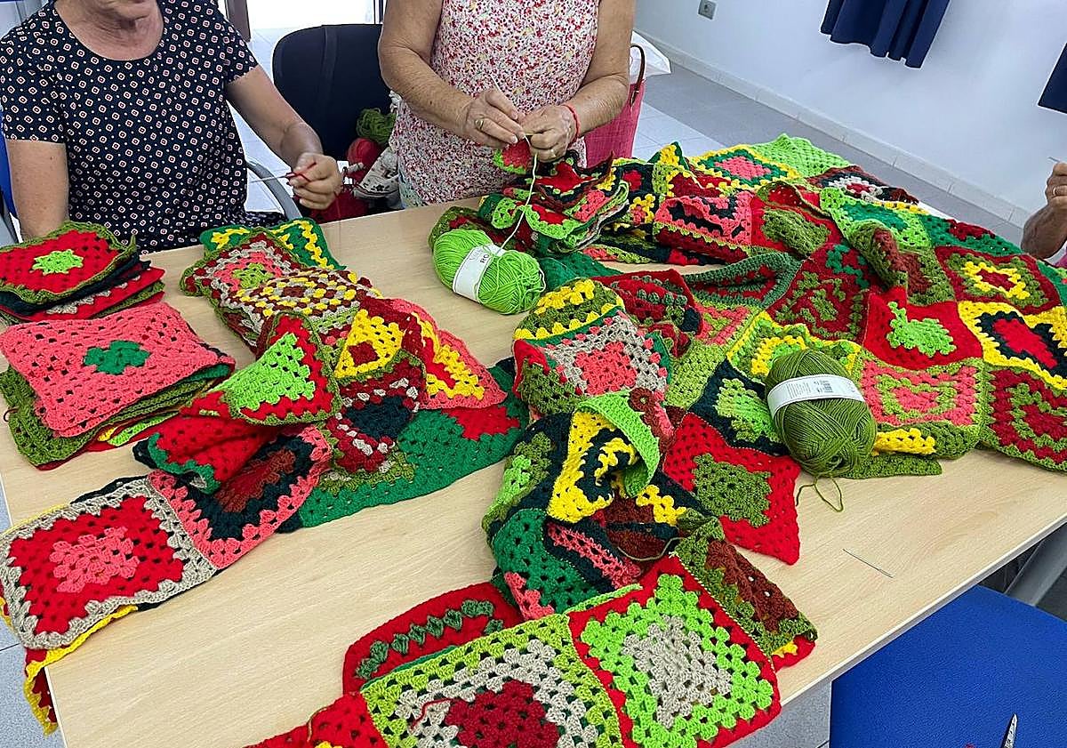 Imagen principal - Imágenes del proceso de elaboración del árbol de Navidad por las vecinas de Veneguera.