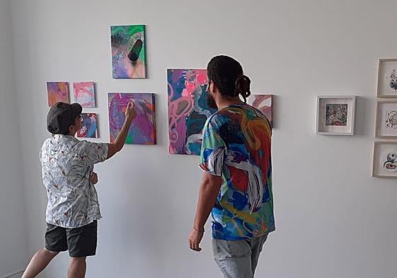 Varios de los protagonistas de la muestra, ante algunas creaciones.