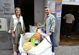 Emilia Atencia y su sobrino Christian Toledo Atencia entregan las donaciones recabadas en el barrio de El Batán.
