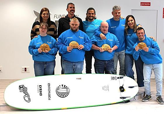 Imagen de los cuatro jóvenes que firman su primer contrato en prácticas como instructores de surf.