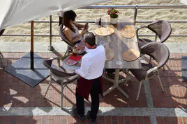 Un camarero atendiendo una mesa en Las Canteras.
