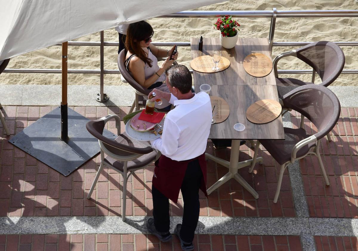 Un camarero atendiendo una mesa en Las Canteras.
