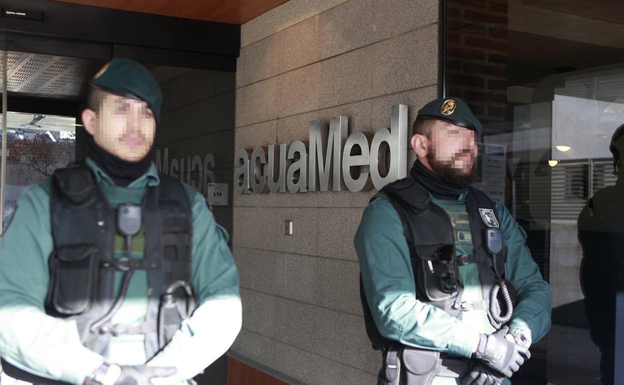 Dos guardias civiles custodian la sede de Acuamed. 