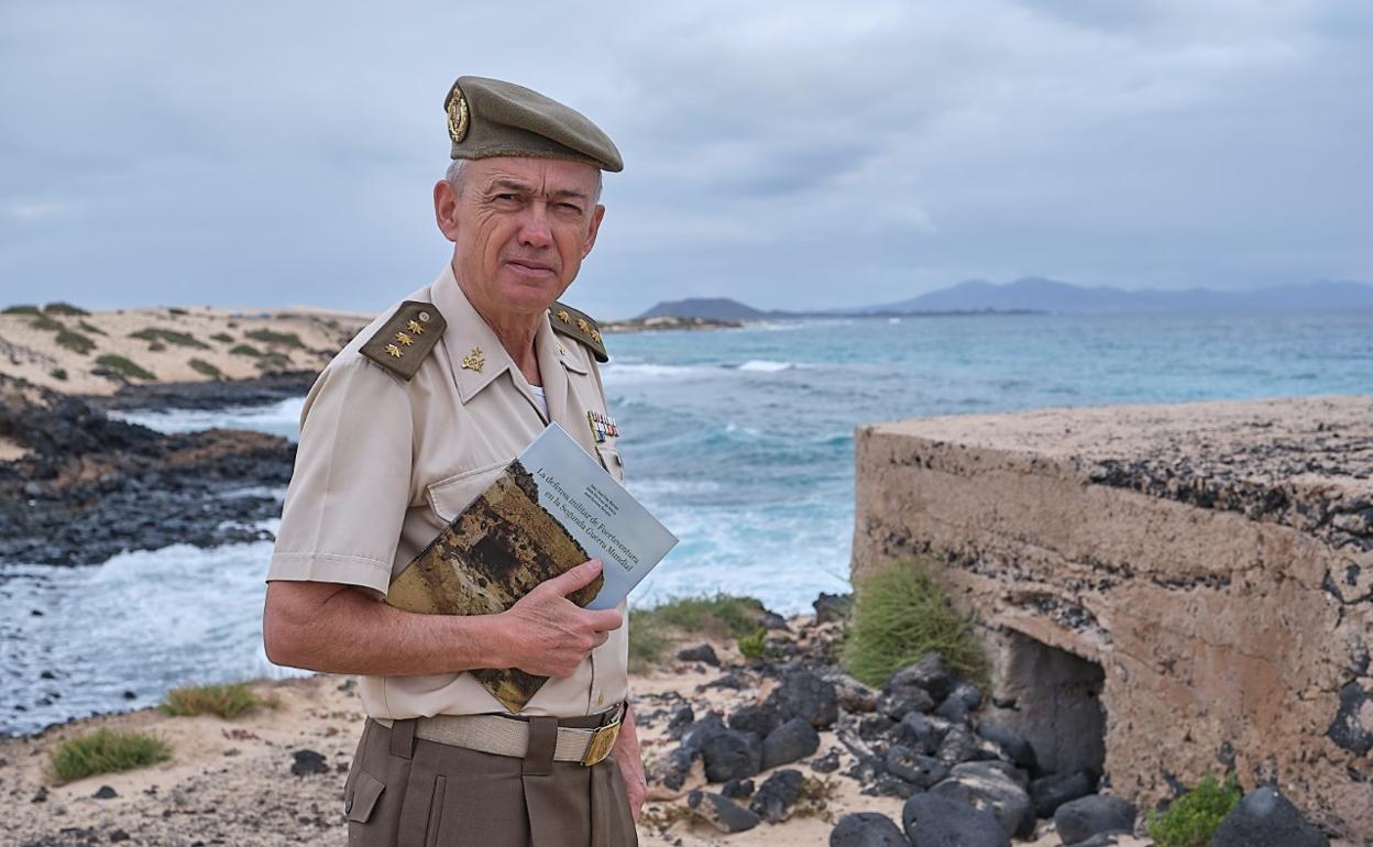 El coronel José Romero Serrano, jefe del departamento de Historia Militar del Siglo XX del Instituto de Historia y Cultura Militar, con su libro en uno de los nidos de ametralladora situados en las playas de las Dunas de Corralejo, en concreto en la playa del Moro. 