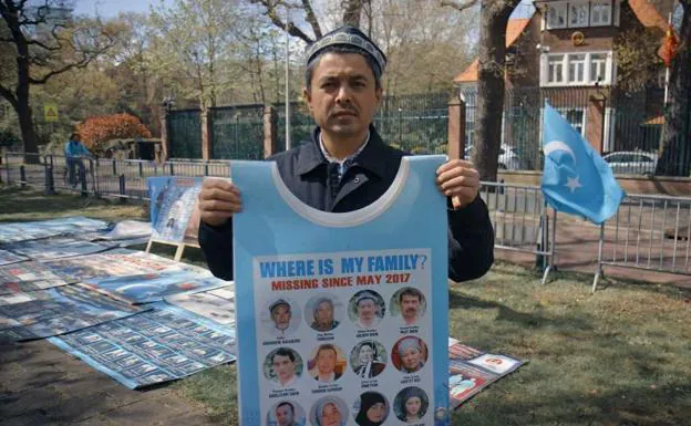 Un hombre sostiene un cartel preguntando dónde está su familia, desaparecida en 2017. 