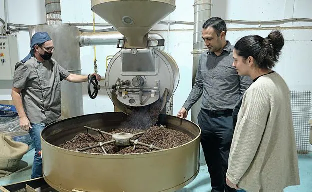 El maestro tostador Roberto Favini y los propietarios de Caffe e Café, Pablo Carranza Brito y María del Pilar Arencibia Ojeda, en la máquina usada desde la fundación de la empresa en El Cotillo. 