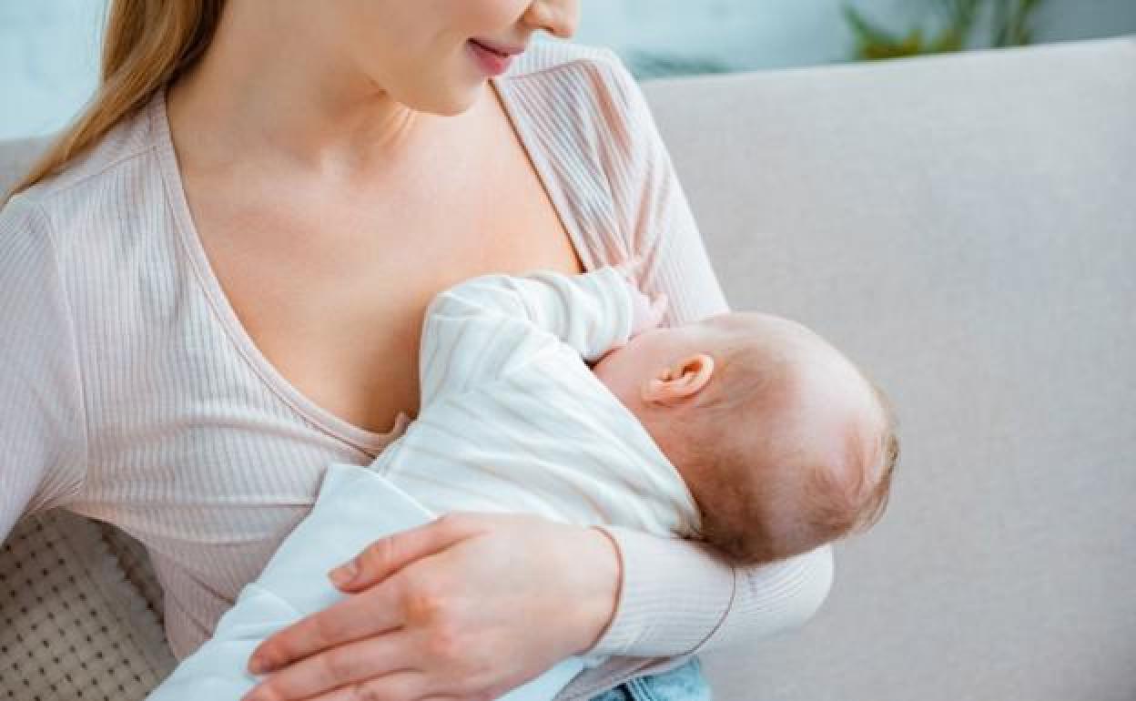 Foto de archivo de una madre dando el pecho al hijo. 