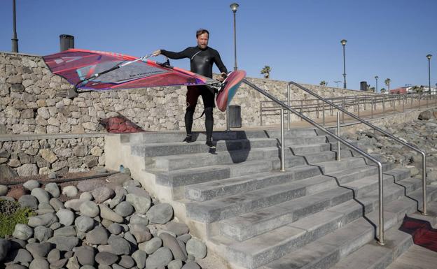 Un windsurfista usa las escaleras para bajar a la playa. La foto fue tomada cuando los operarios aún estaban colocando la madera sobre la rampa. 