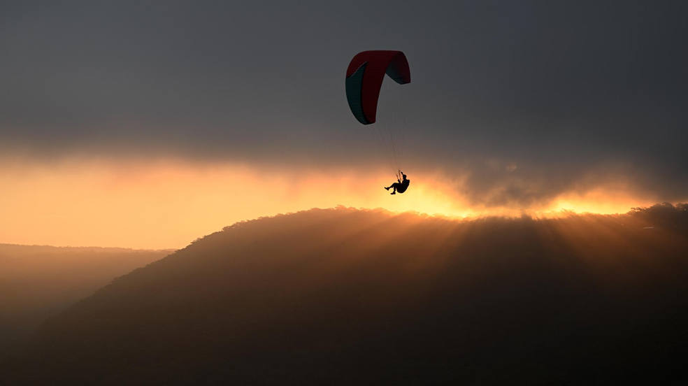 Un parapentista surca el cielo desde el popular punto de lanzamiento de Bald Hill, Stanwell Tops, Nueva Gales del Sur. 