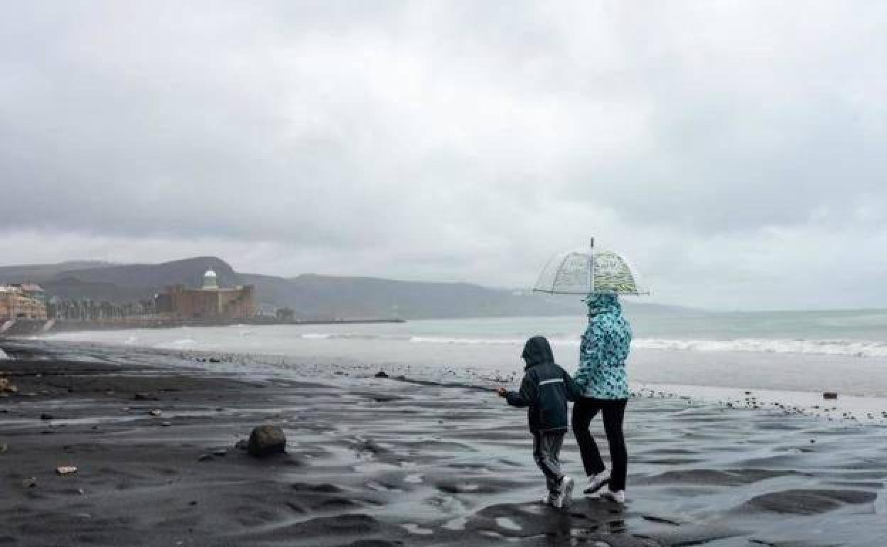 Paseantes por la playa de Las Canteras. 