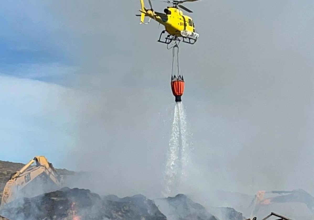 Helicópteros y maquinaria pesada refrescan el fuego en la planta de compostaje de Tenerife