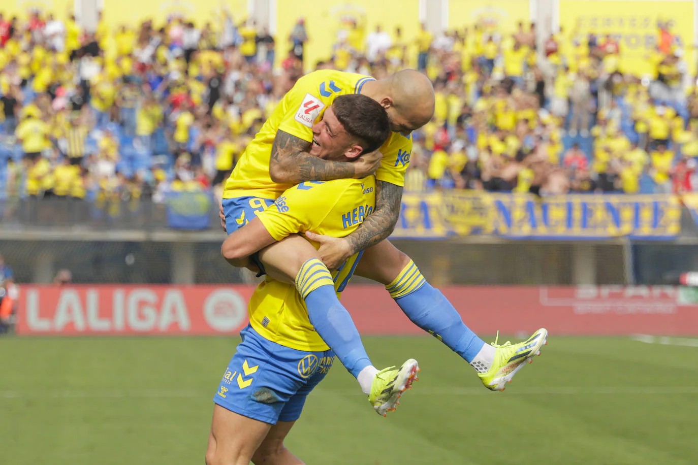 Juanma Herzog se abraza con Sandro tras su gol.