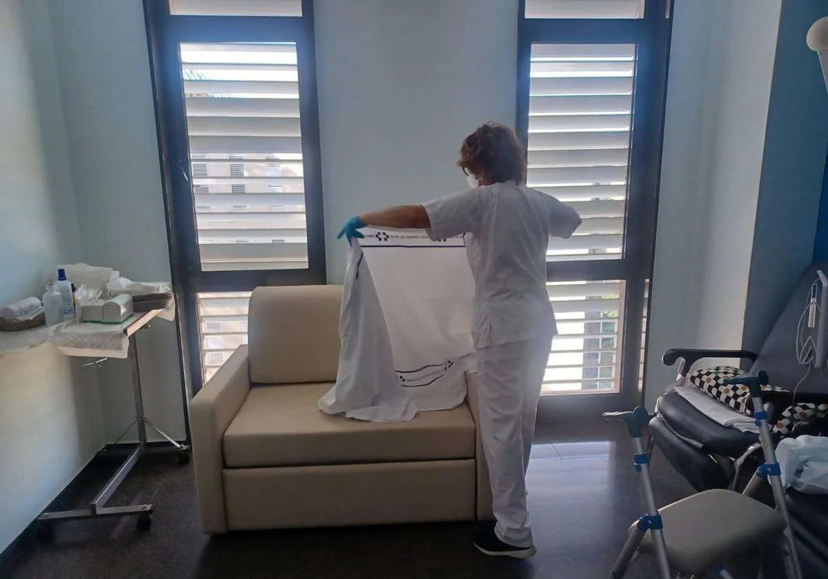 Una enfermera cubre uno de los nuevos sillones convertibles en cama.