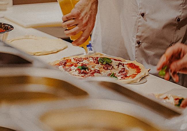 Las pizzas se elaboran frente a los comensales en la sala.
